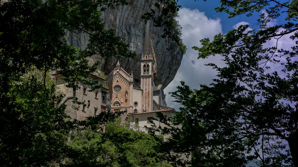 La chiesa italiana è incollata a un pendio roccioso.  Sotto si apre l’abisso